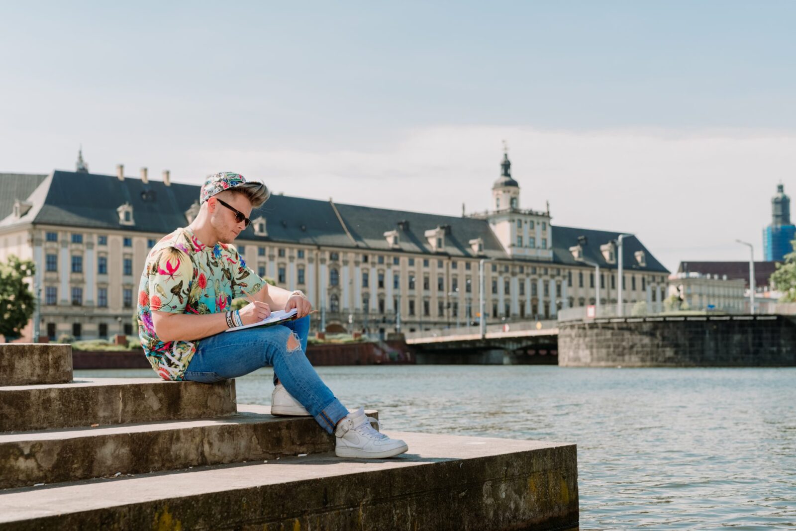 student na tle gmachu głównego UWr