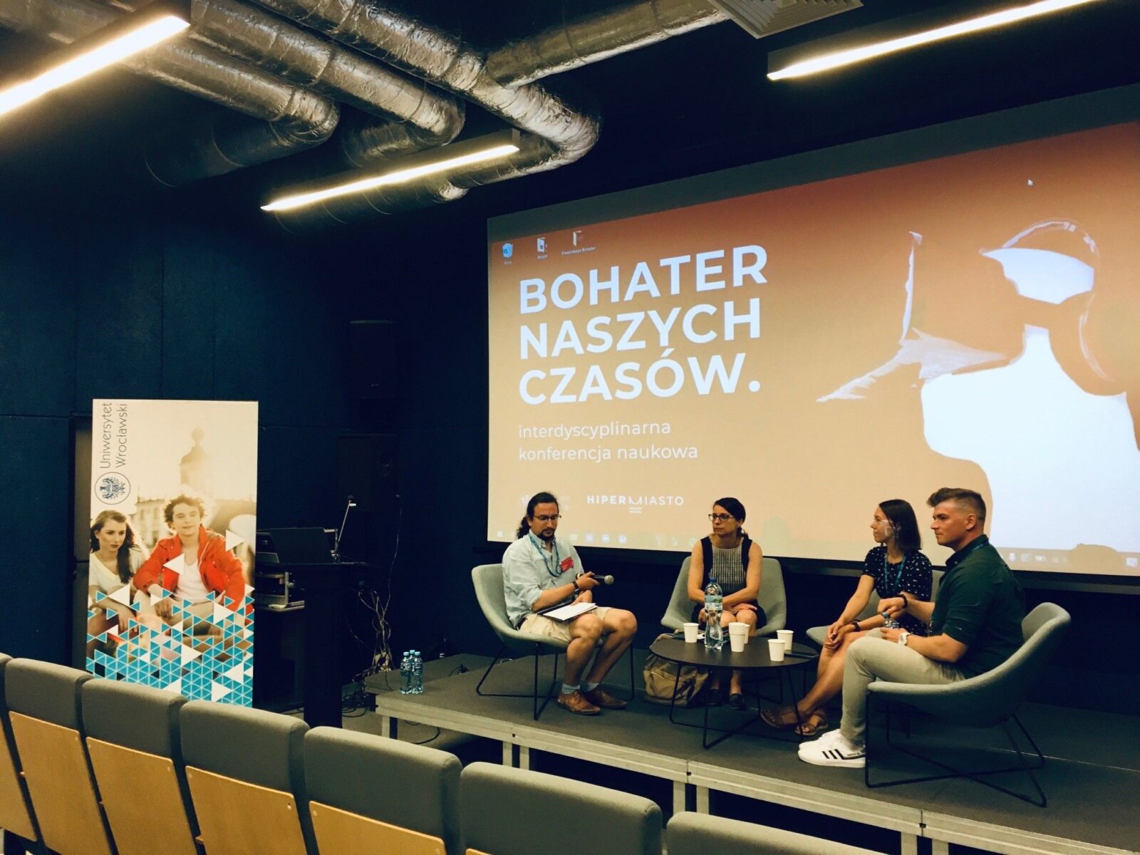 grupa osób na widowni i scenie sali konferencyjnej