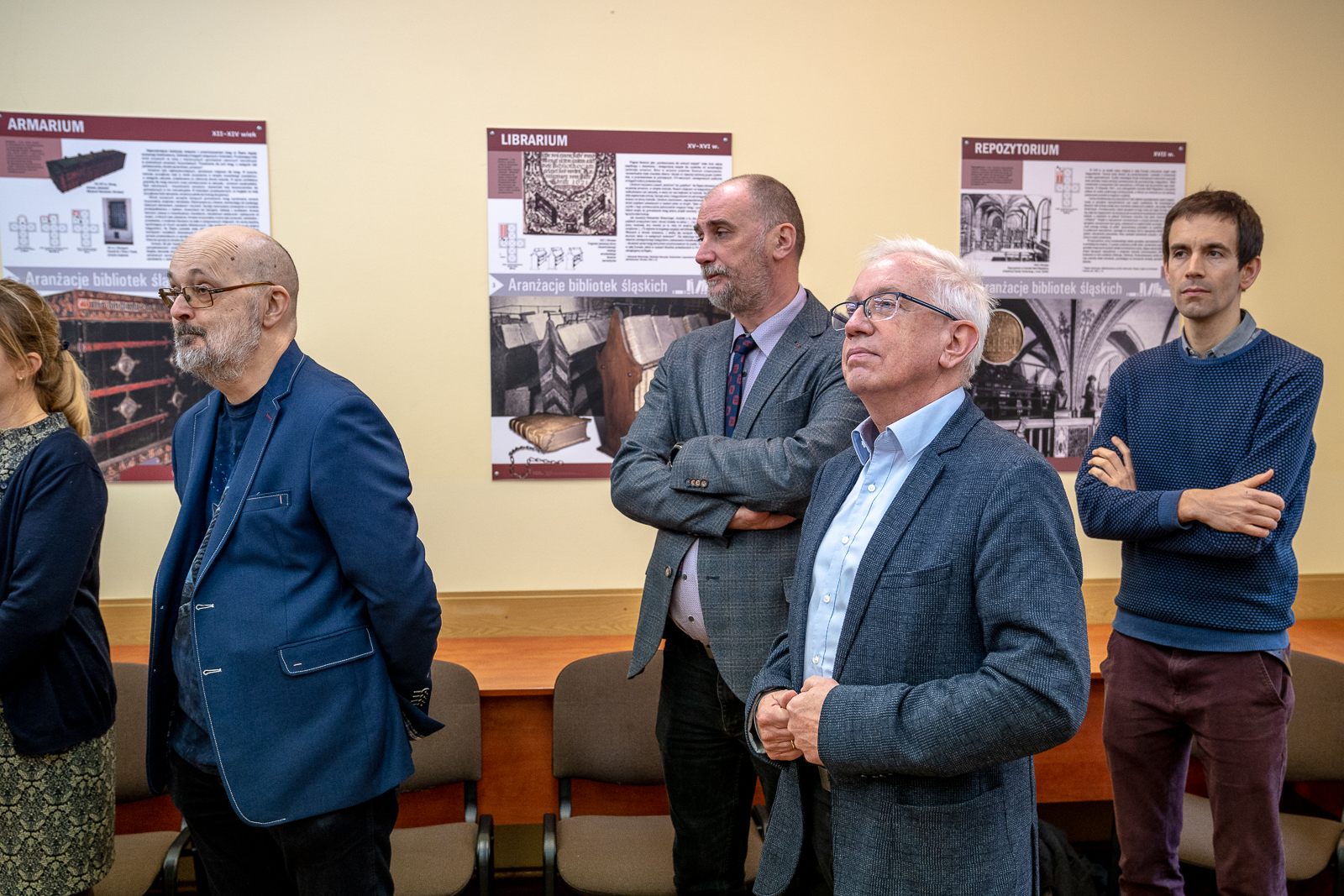 czterej mężczyżni w różnym wieku zwóceni w lewą stronę i patrzący przed siebie