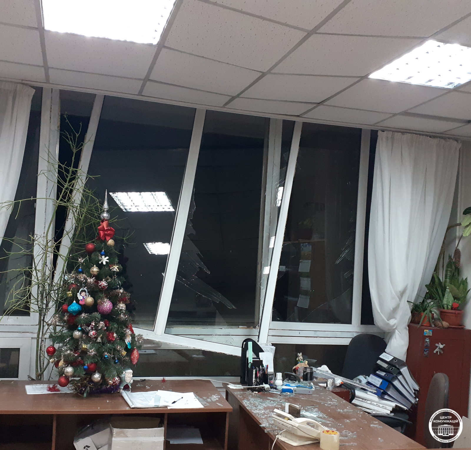 pokój ze śladami zniszczenia wybite okna na stole choinka z bombkami
