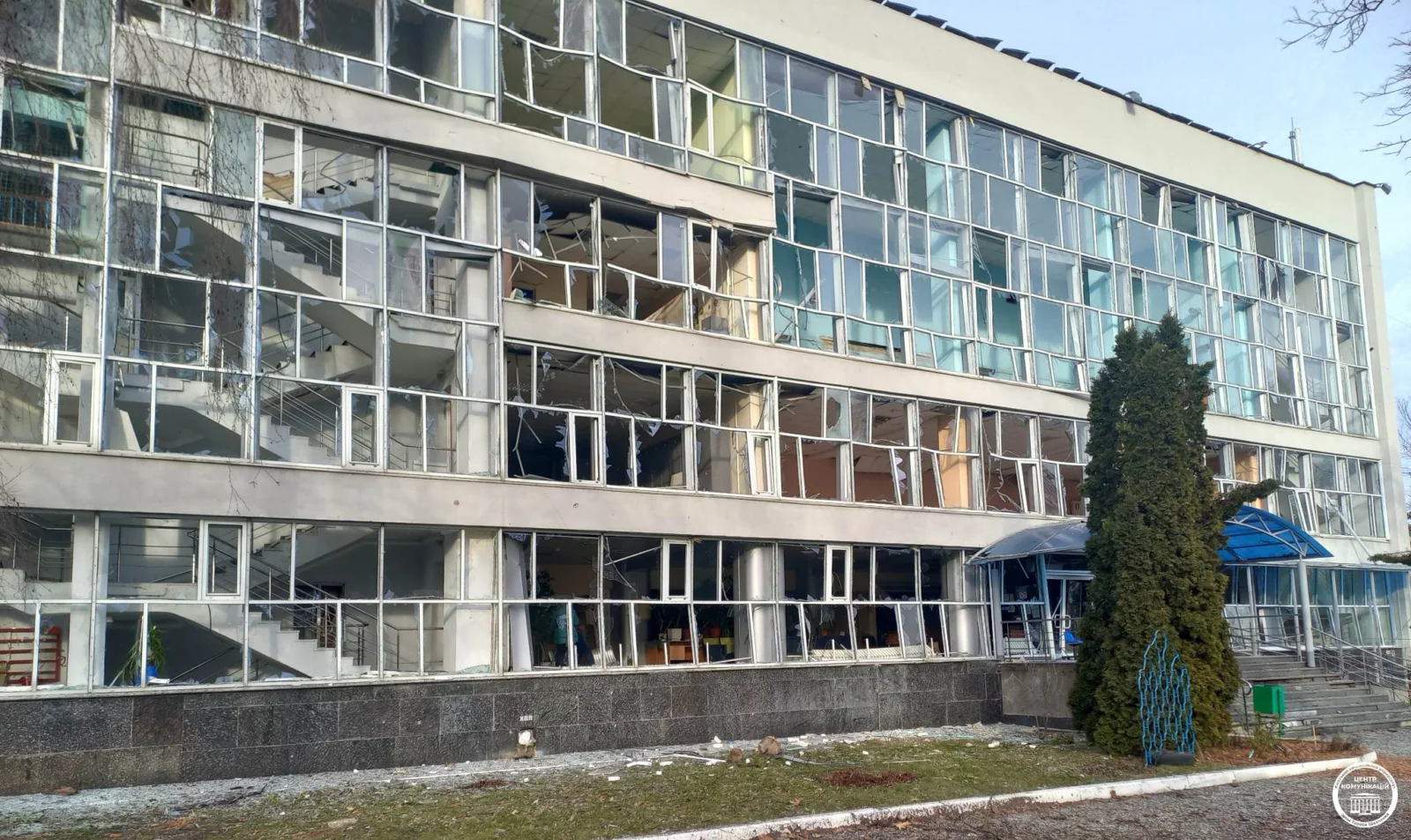 duży szary budynek z wybitymi oknami