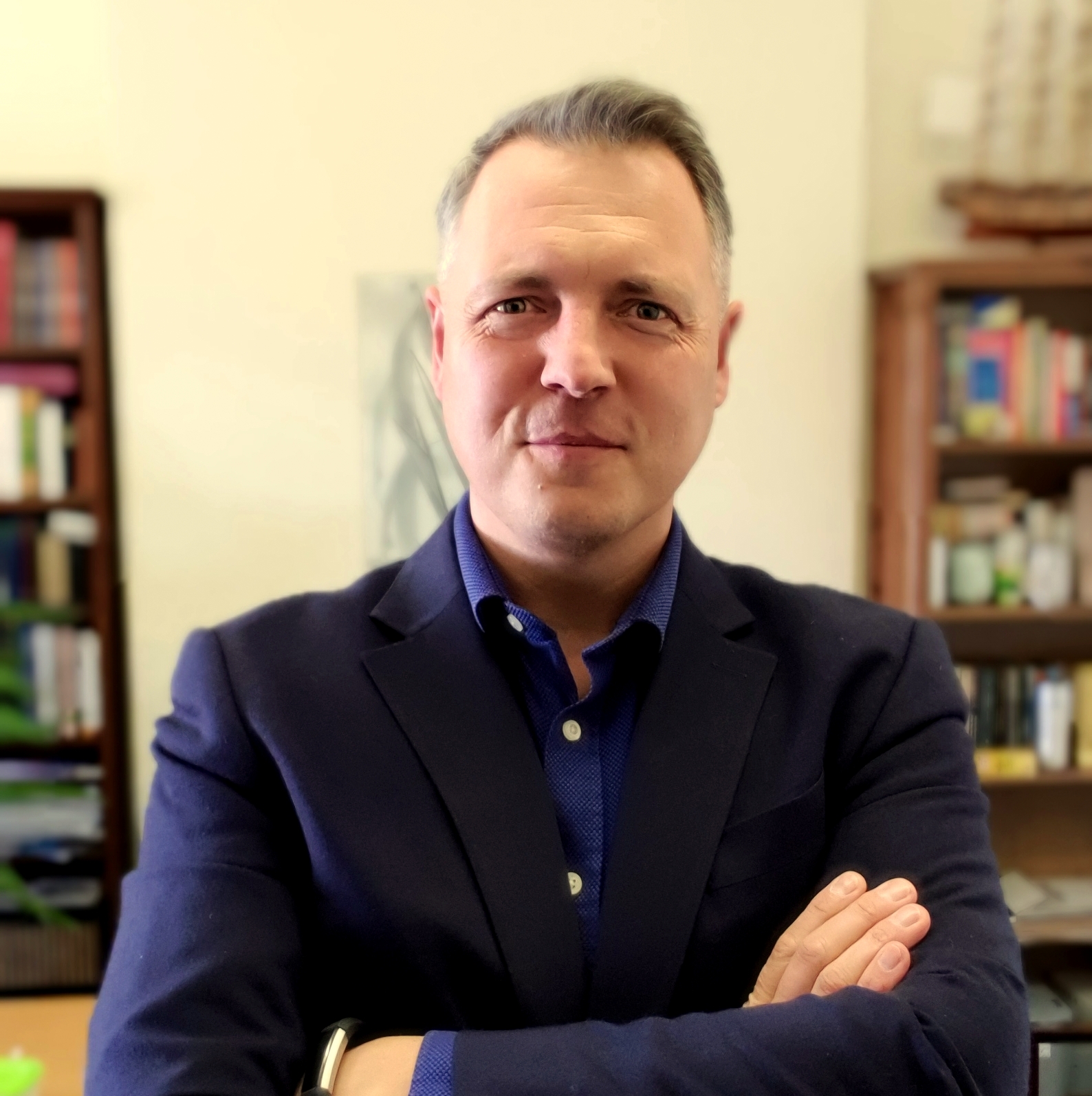 mężczyzna w średnim wieku, w tle książki