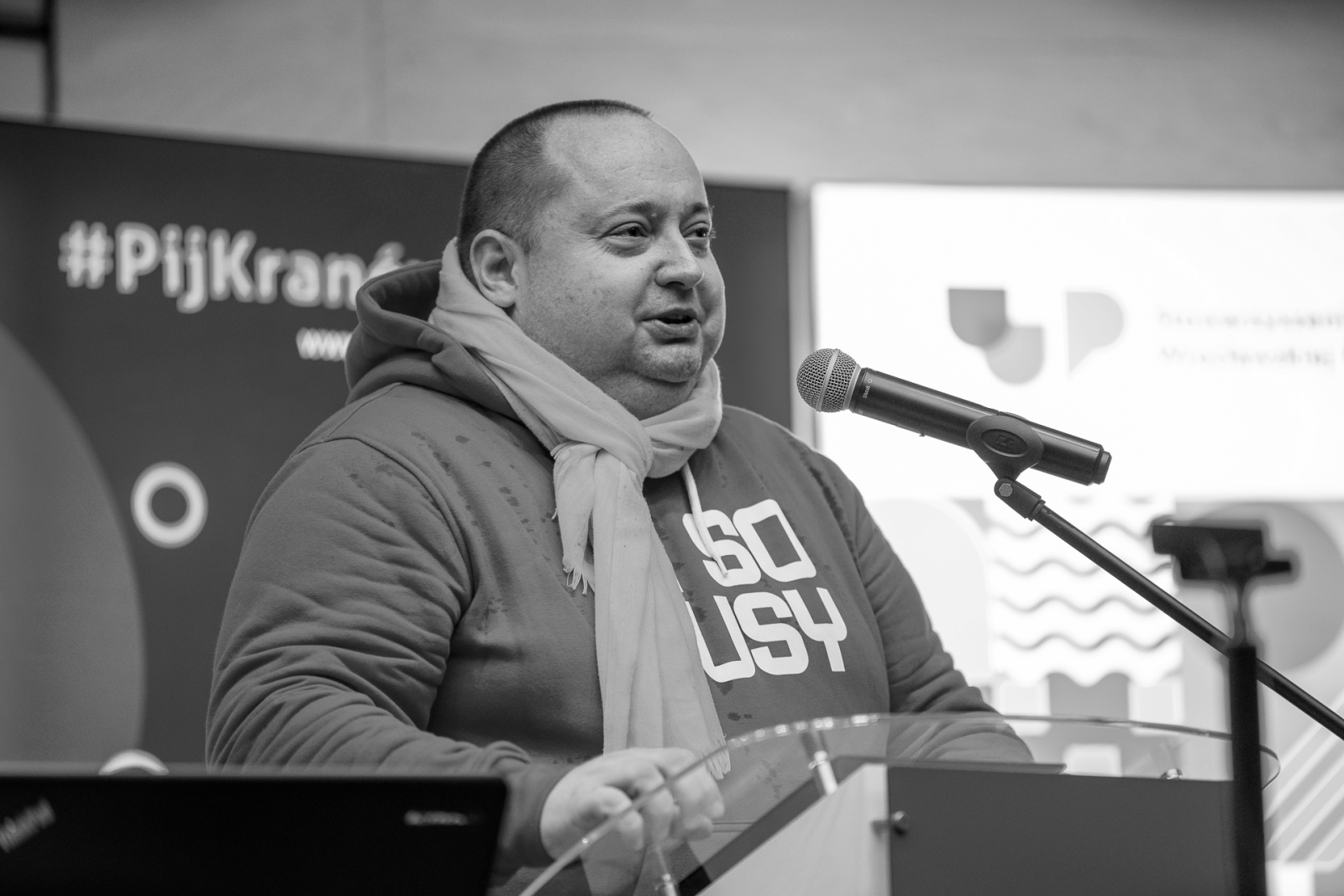 Młody mężczyzna w szaliku przy mikrofonie