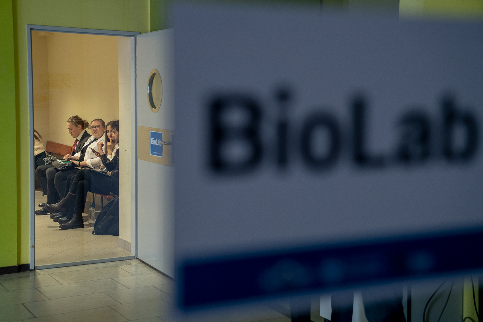 grupa młodych kobiet i mężczyzna siedzacy na ławce