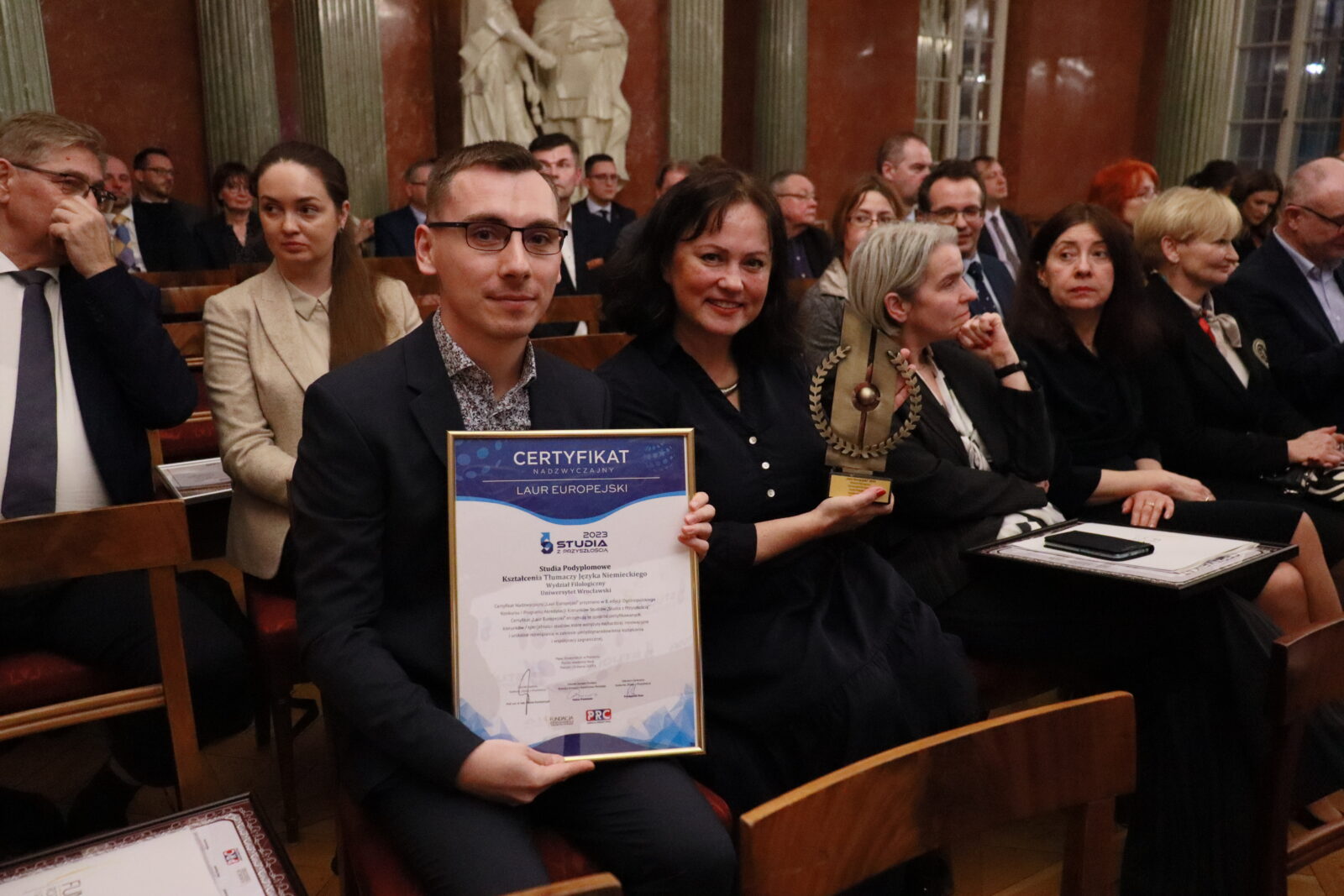 młody mężczyzna z dyplomem w ręce