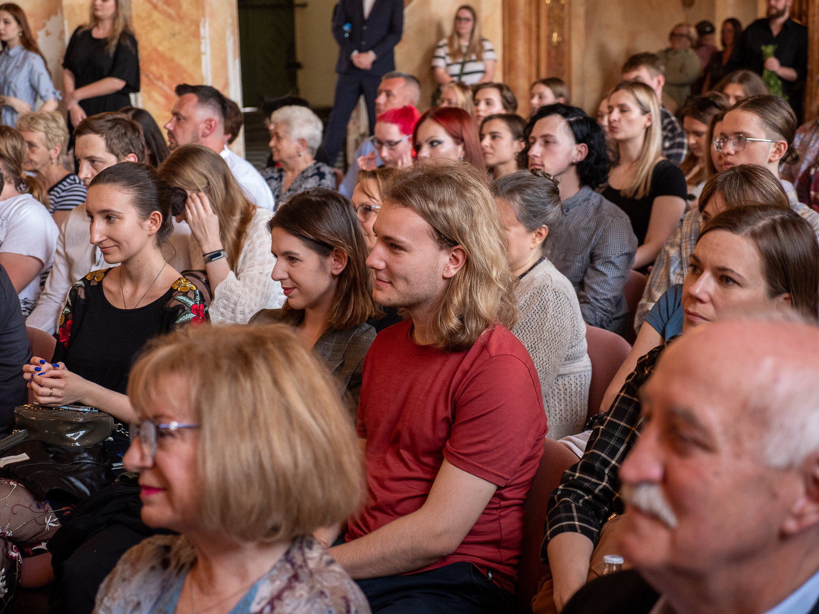 Publiczność zgromadzona w zabytkowej sali.