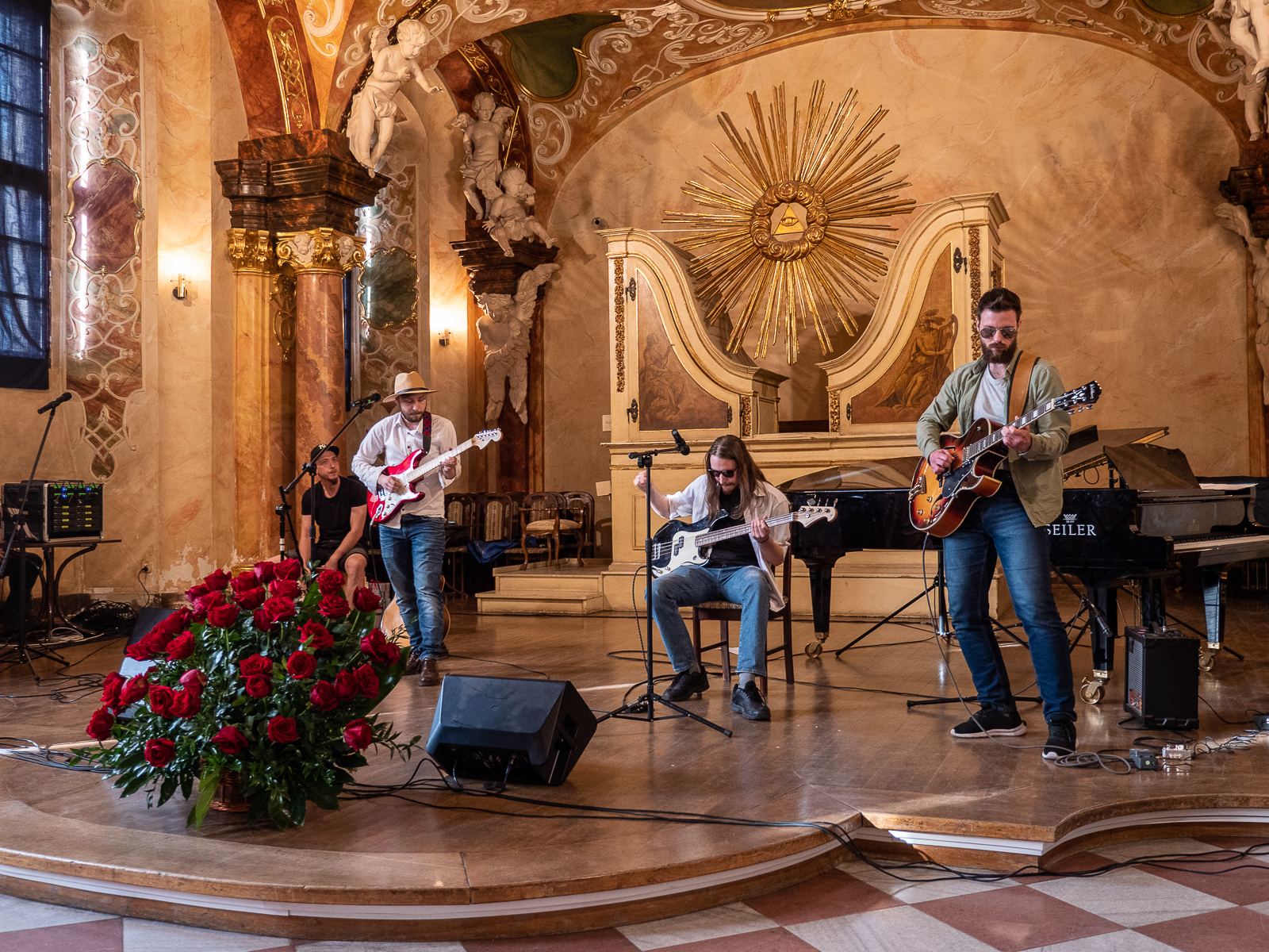 Trzech mężczyzn grających na gitarach na scenie.