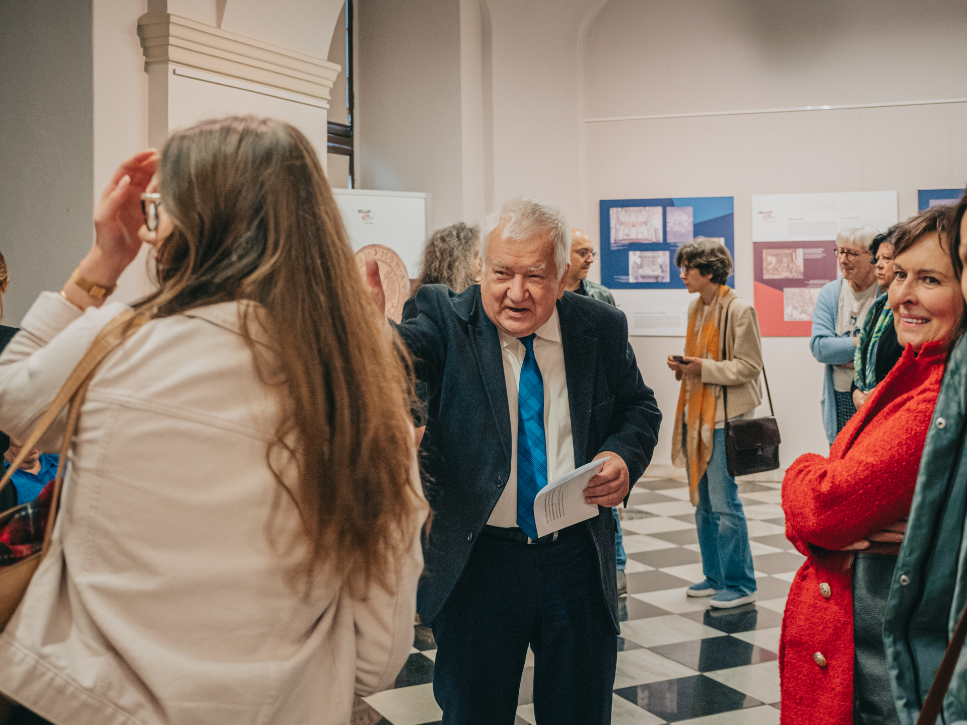 starszy mężczyzna stoi wśród ludzi