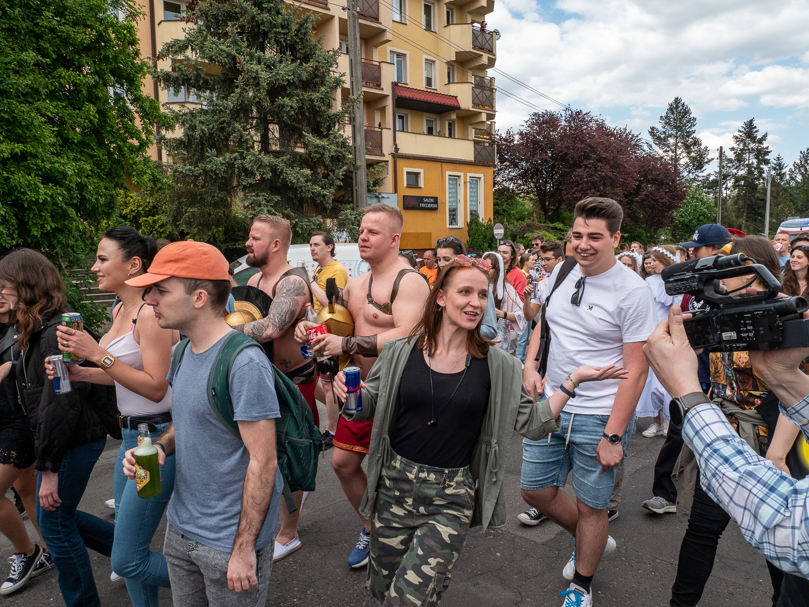 Ludzie idący w pochodzie juwenaliowym ulicami Wrocławia.