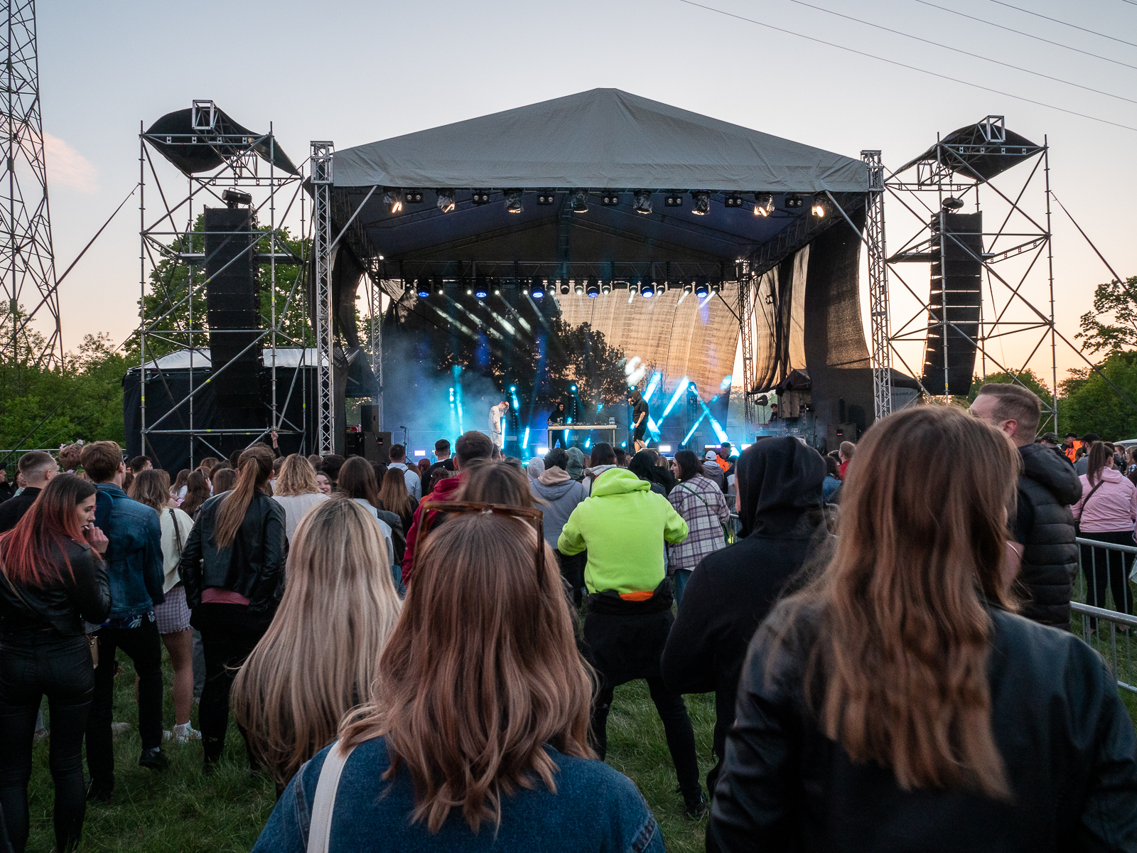 Scena, na której osbywa się koncert. Publiczność przed sceną. Dość ciemno, wieczór.