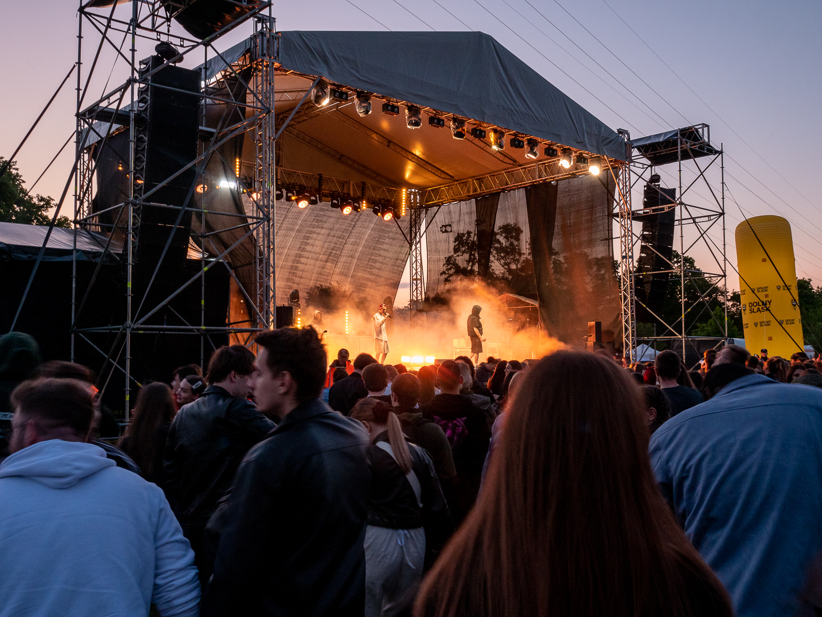 Scena, na której odbywa się koncert. Na scenie dym, publiczność przed sceną. Wieczór, dość ciemno.