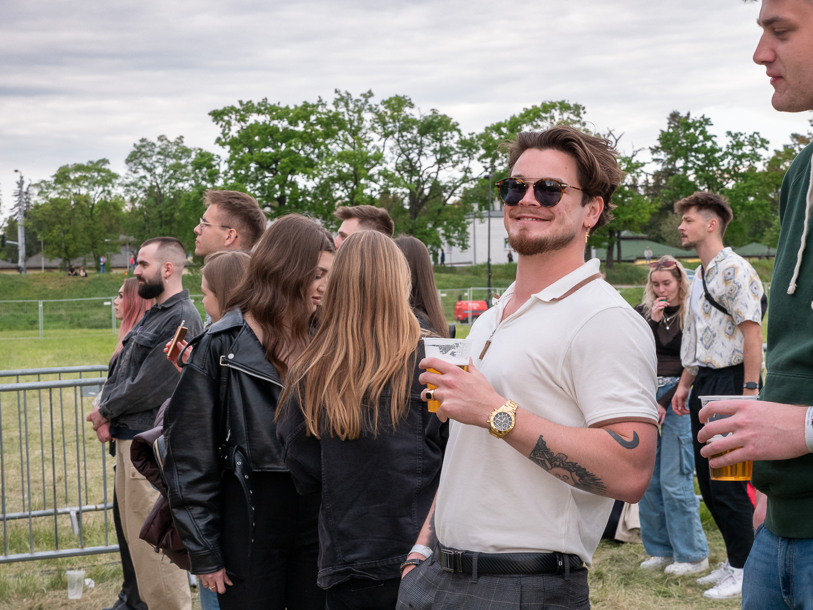 Grupa studentów bawiących się na koncercie podczas Juwenaliów. Na pierwszym planie student w białej koszulce polo i okularach słonecznych.