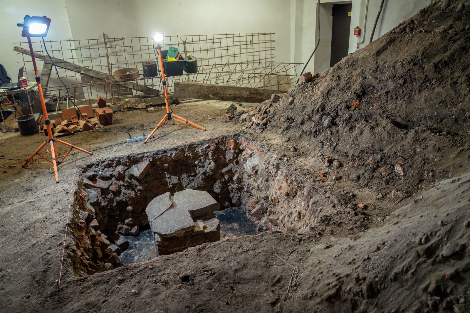 badania archeologiczne w piwnicy instytutu historycznego, kamienne fragmenty starych budynku