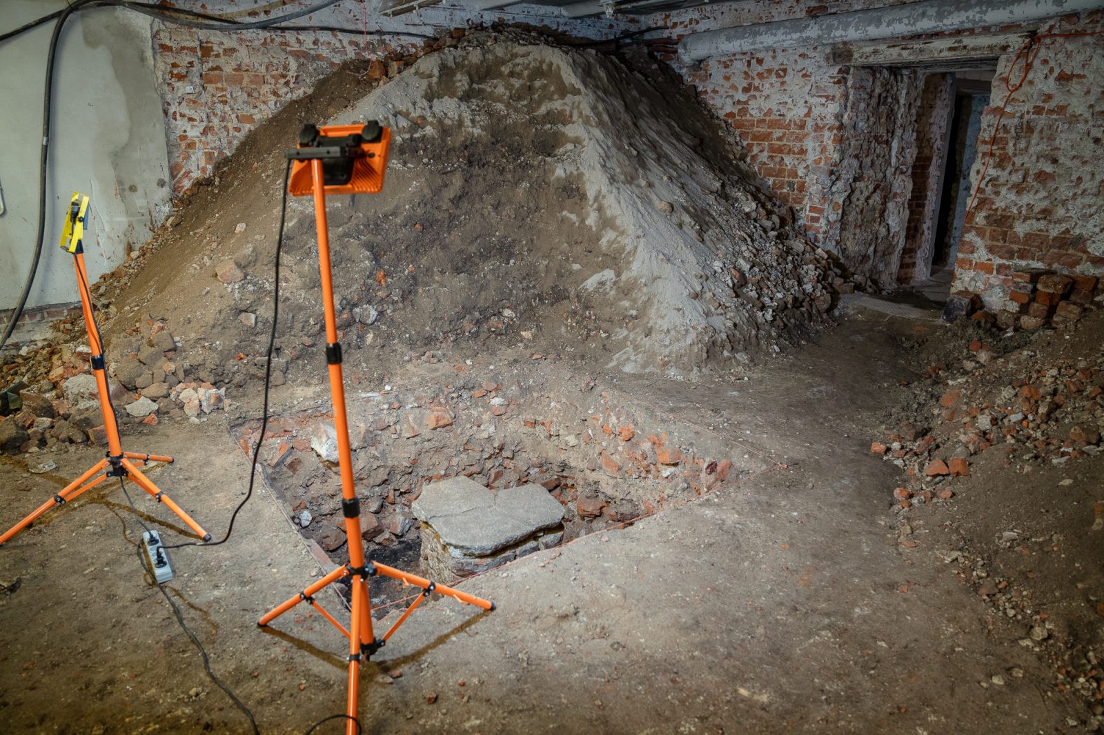 badania archeologiczne w piwnicy instytutu historycznego, kamienne fragmenty starych budynku