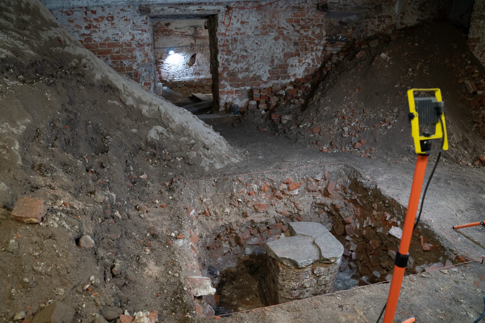 badania archeologiczne w piwnicy instytutu historycznego, kamienne fragmenty starych budynku