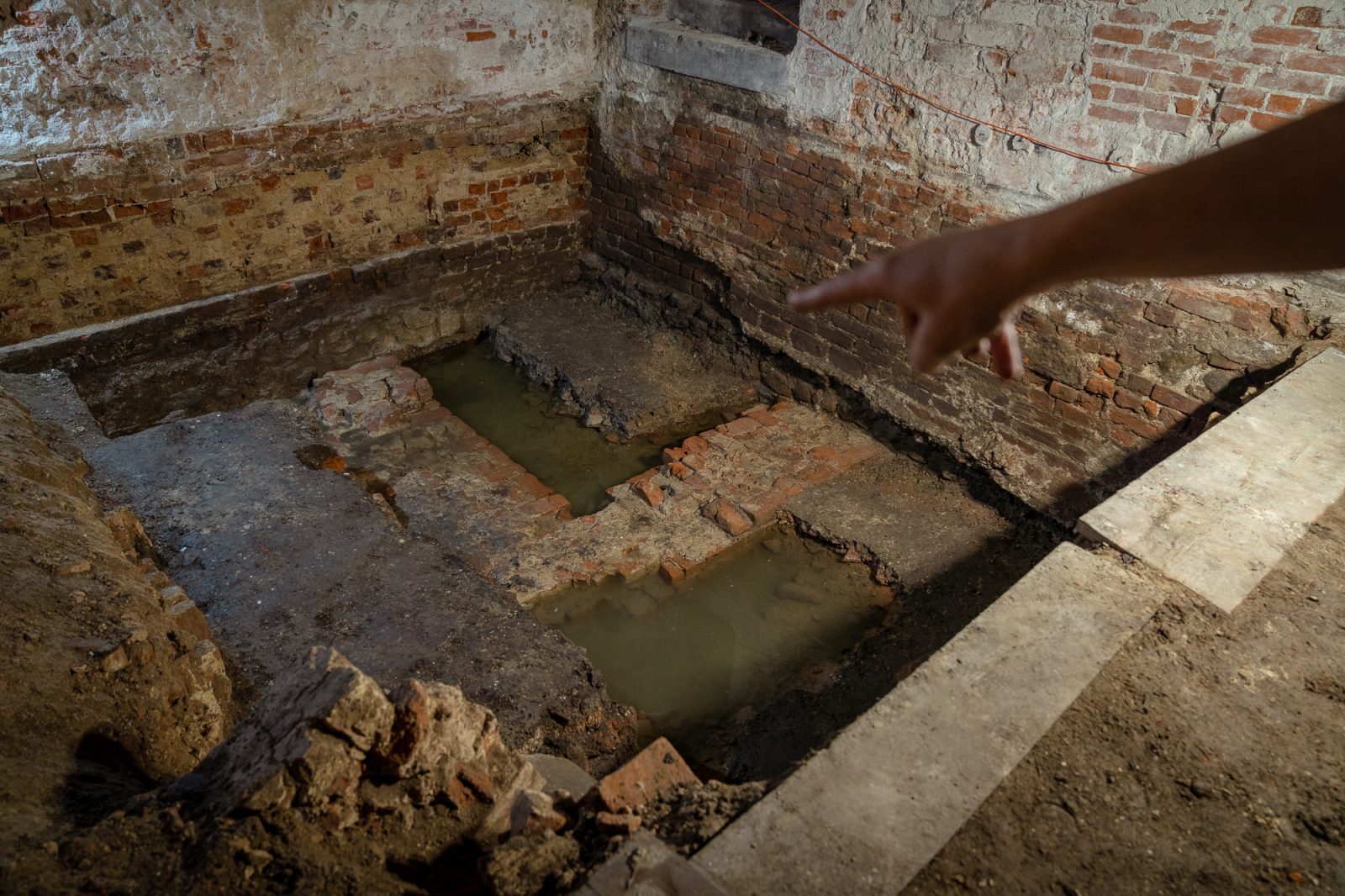 badania archeologiczne w piwnicy instytutu historycznego, kamienne fragmenty starych budynku