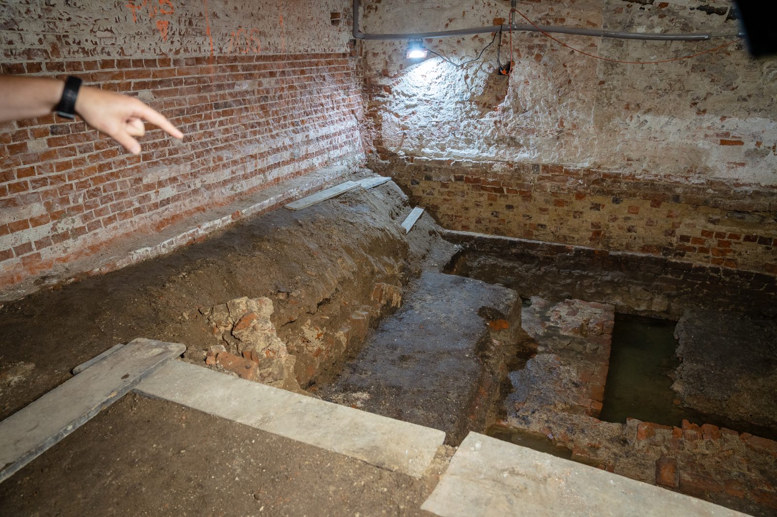 badania archeologiczne w piwnicy instytutu historycznego, kamienne fragmenty starych budynku