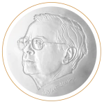 srebrny, okrągły medal z wizerunkiem głowy starszego mężczyzny w okularach, widocznego z lewego półprofilu