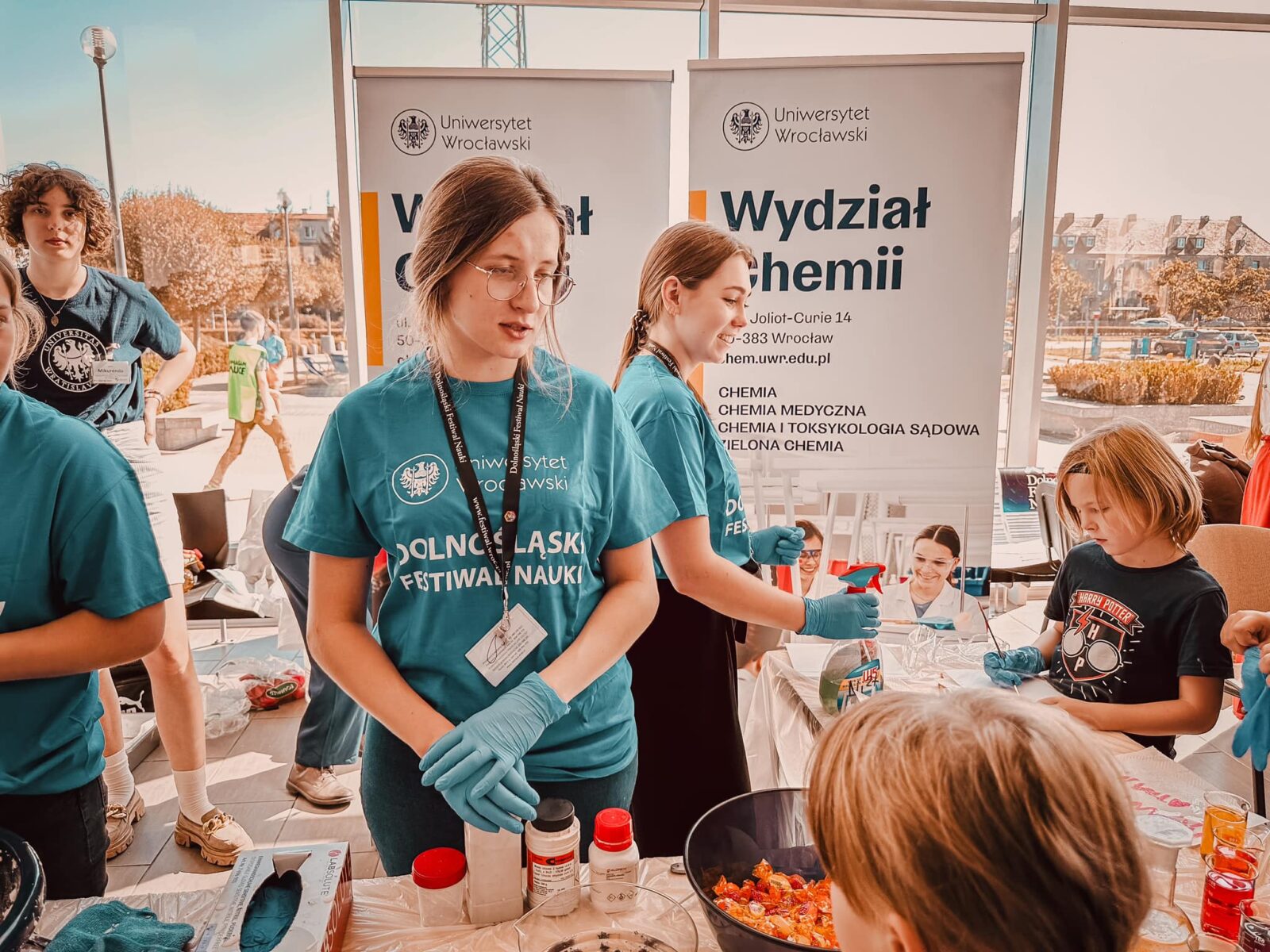 Studentka w niebieskiej koszulce na stoisku na Dolnośląskim Festiwalu Nauki