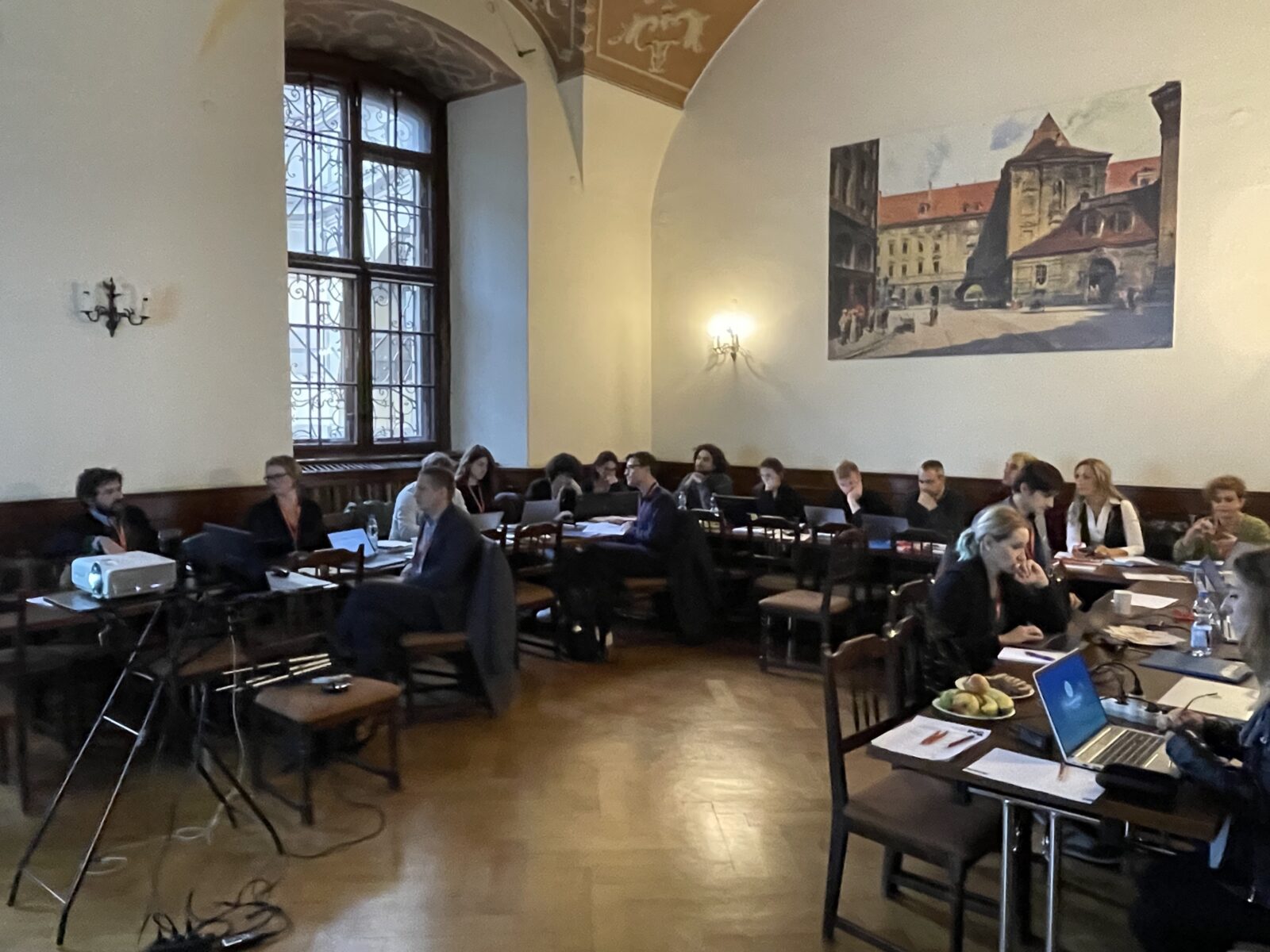 Sala Klubu uczelni, ludzie siedzący przy stołach i dyskutujący
