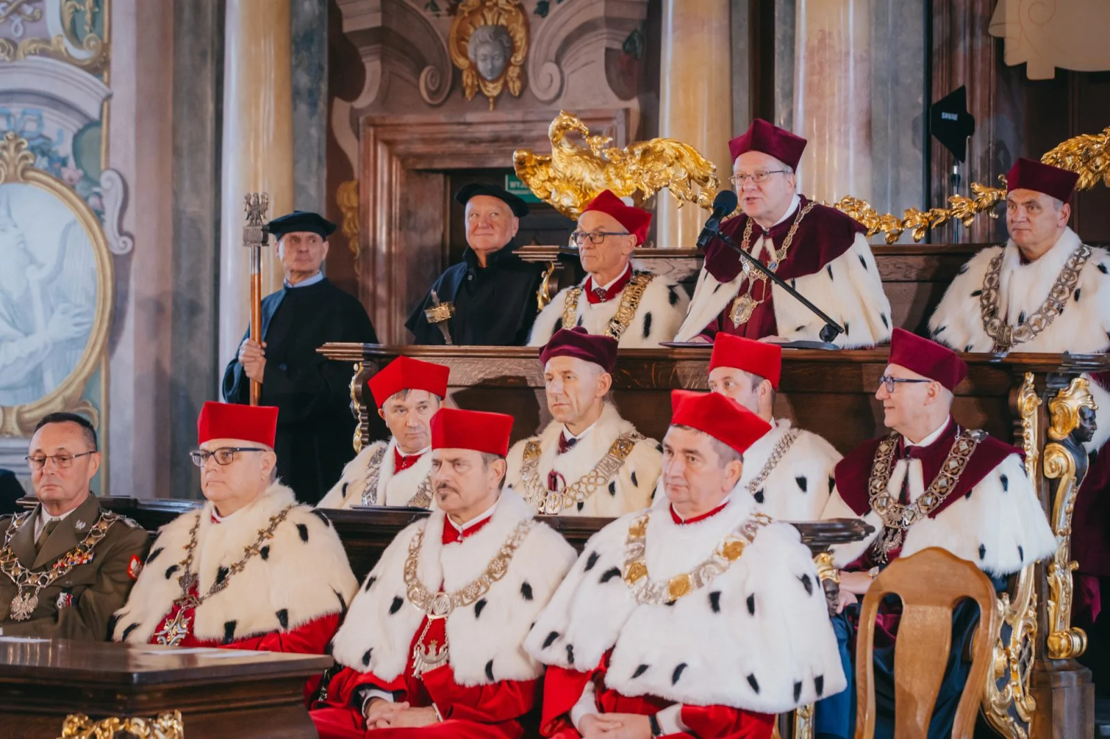 grupa mężczyzn w histroycznych czerwonych płaszczach