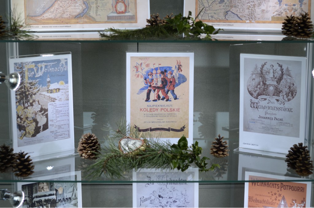 zdjęcie planszy z historycznym tekstem oraz szyszką, zieloną gałazką