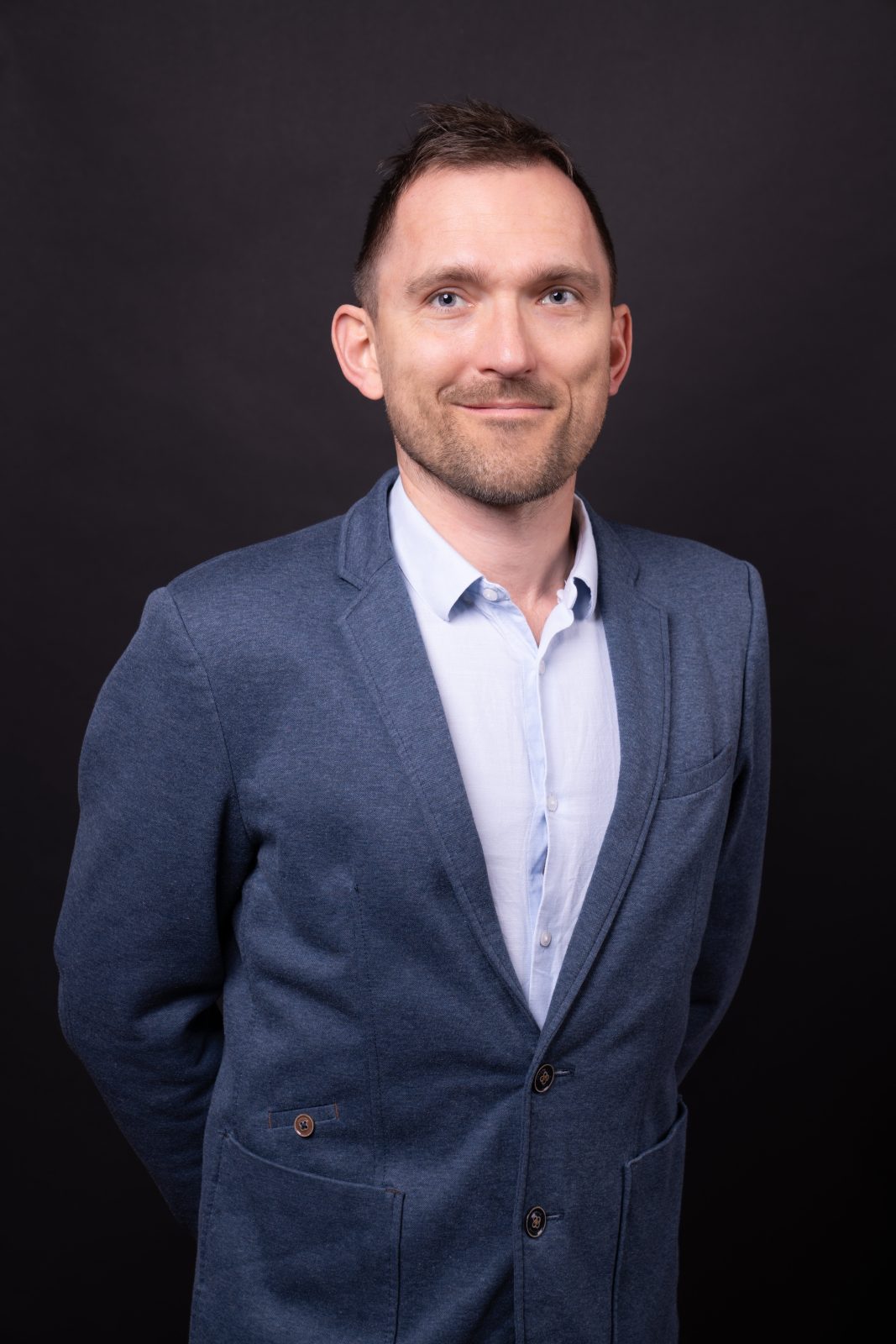 Mężczyzna w garniturze, z rękami splecionymi za plecami, stojący na czarnym tle. Dr hab. Piotr Sorokowski, prof. UWr, członek Rady UWr na kadencję 2025-2028