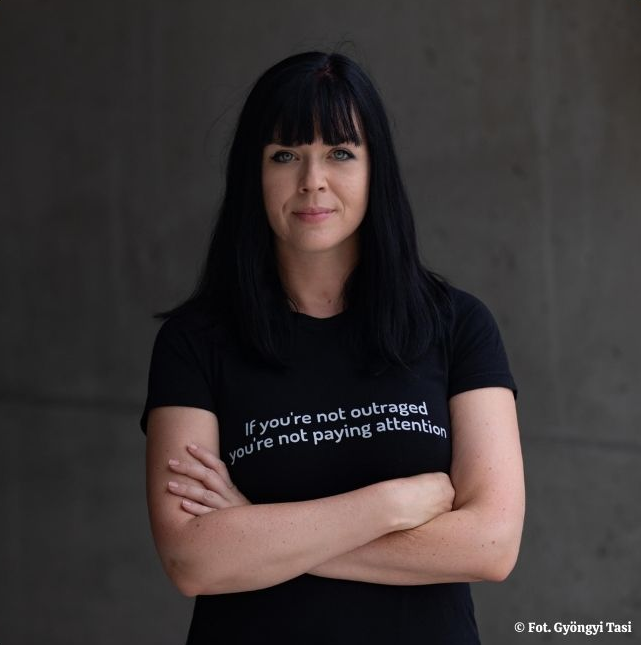 zdjęcie przedstawiające młodą uśmiechniętą kobietę w ciemnych włosach i w ciemnym tshircie