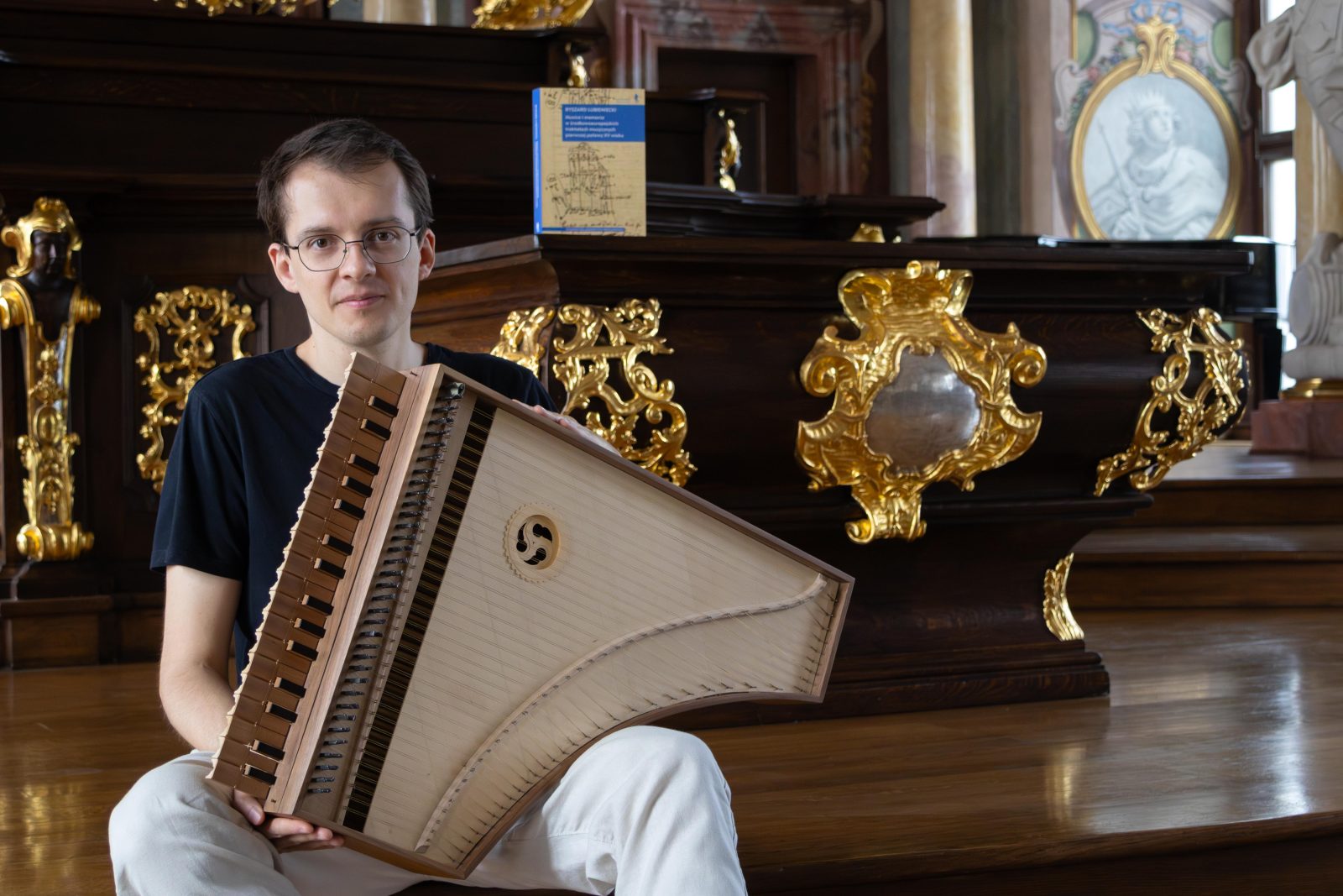 mężczyzna z instrumentem w barokowej sali