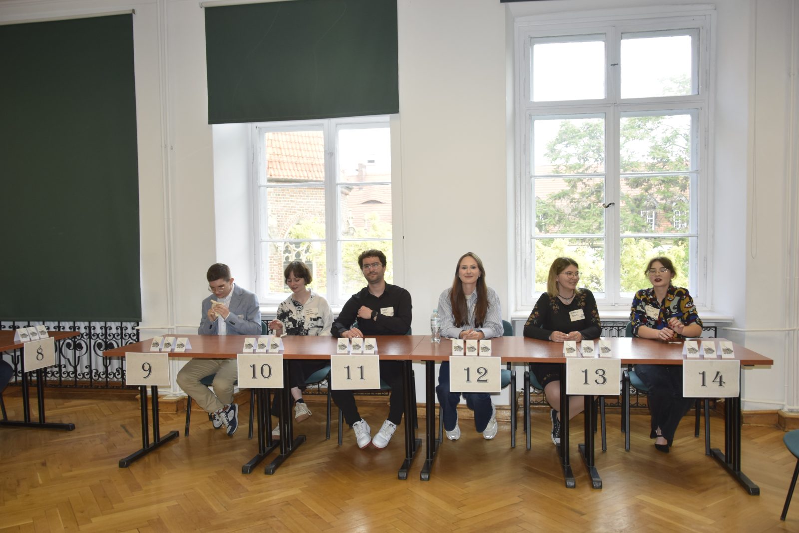 grupa młodych ludzi siedząca w ławkach