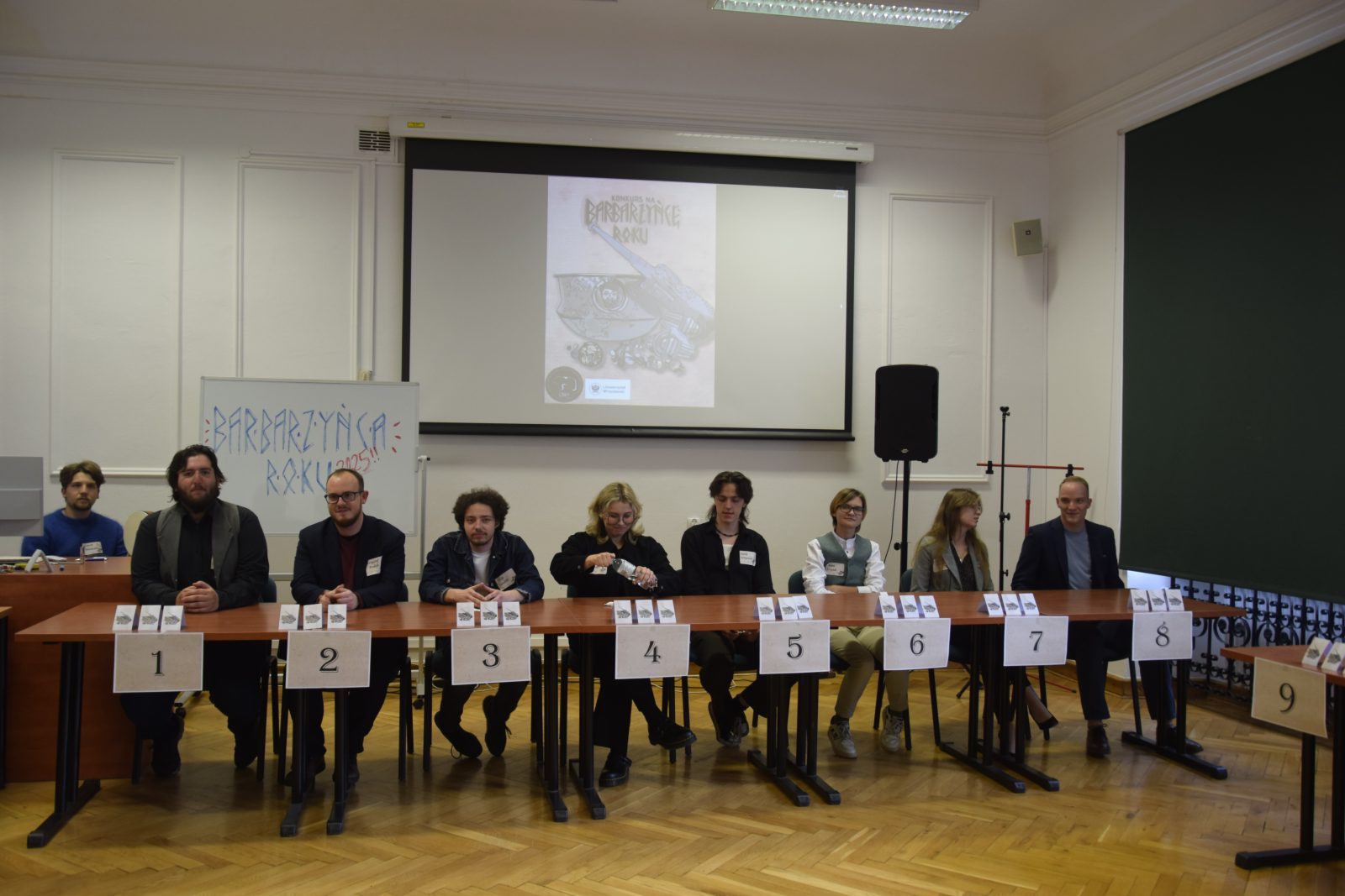 grupa młodych ludzi siedząca w ławkach