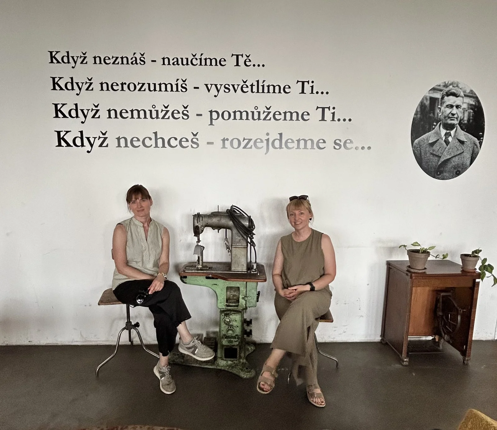 dwie kobiety siedzą koło maszyny do szycia