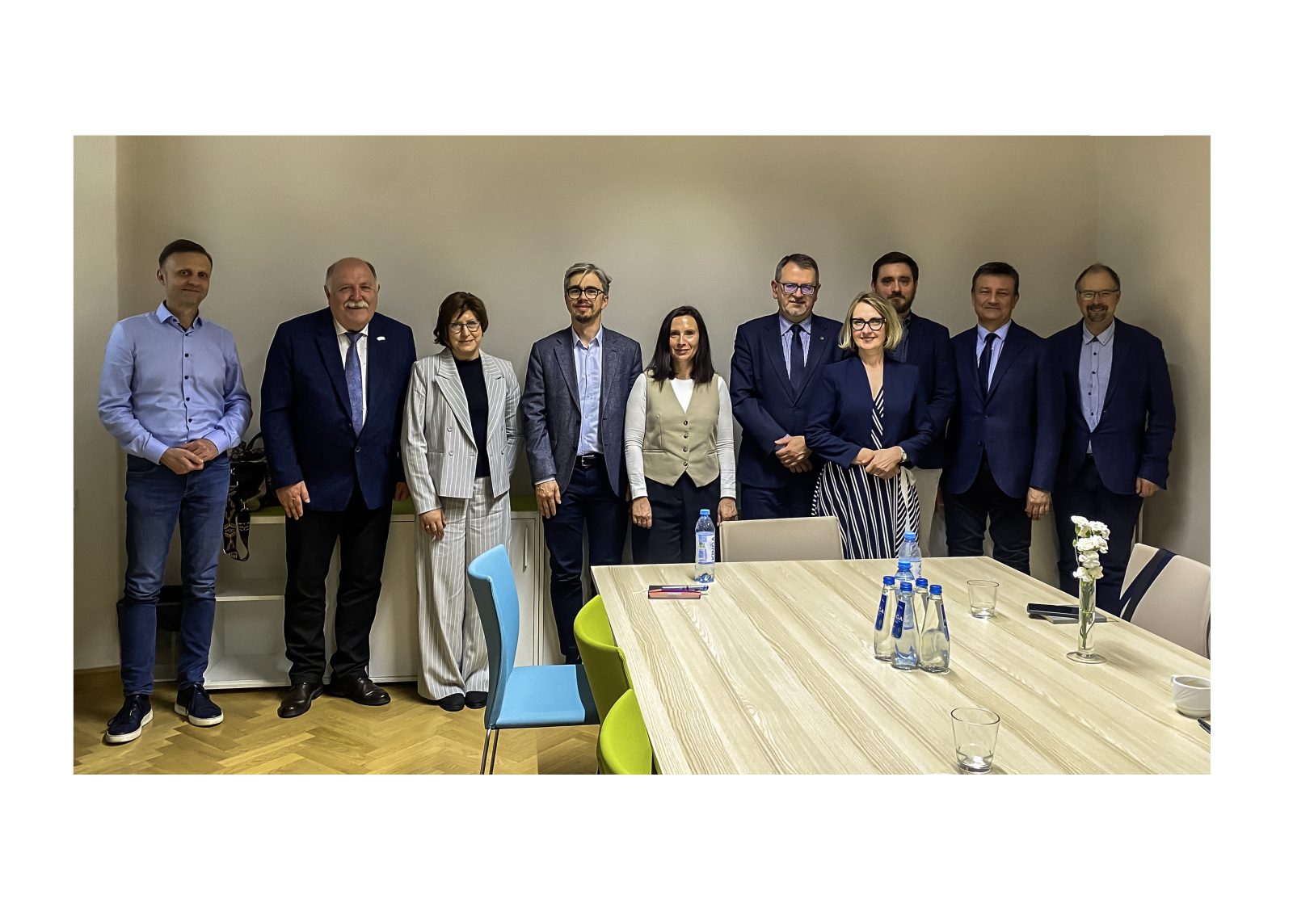 zdjęcie przedstawiające grupę ludzi ubranych wizytowo w sali