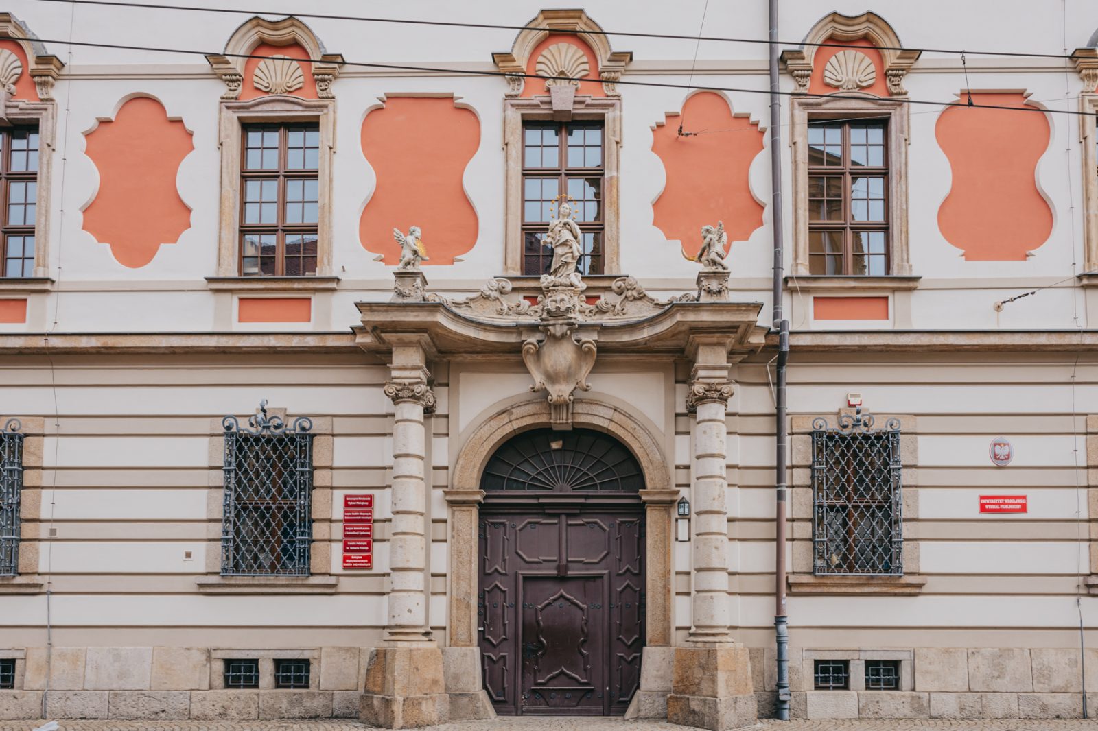 Fasada budynku z drzwiami wejściowymi i pomarańczowymi zdobieniami