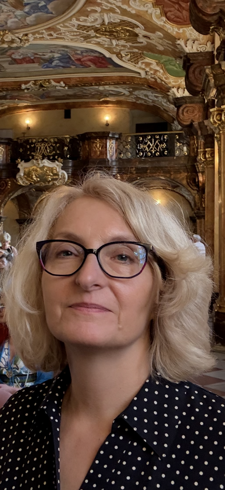 młoda kobieta w okularach, uśmiechnięta, ubrana elegancko