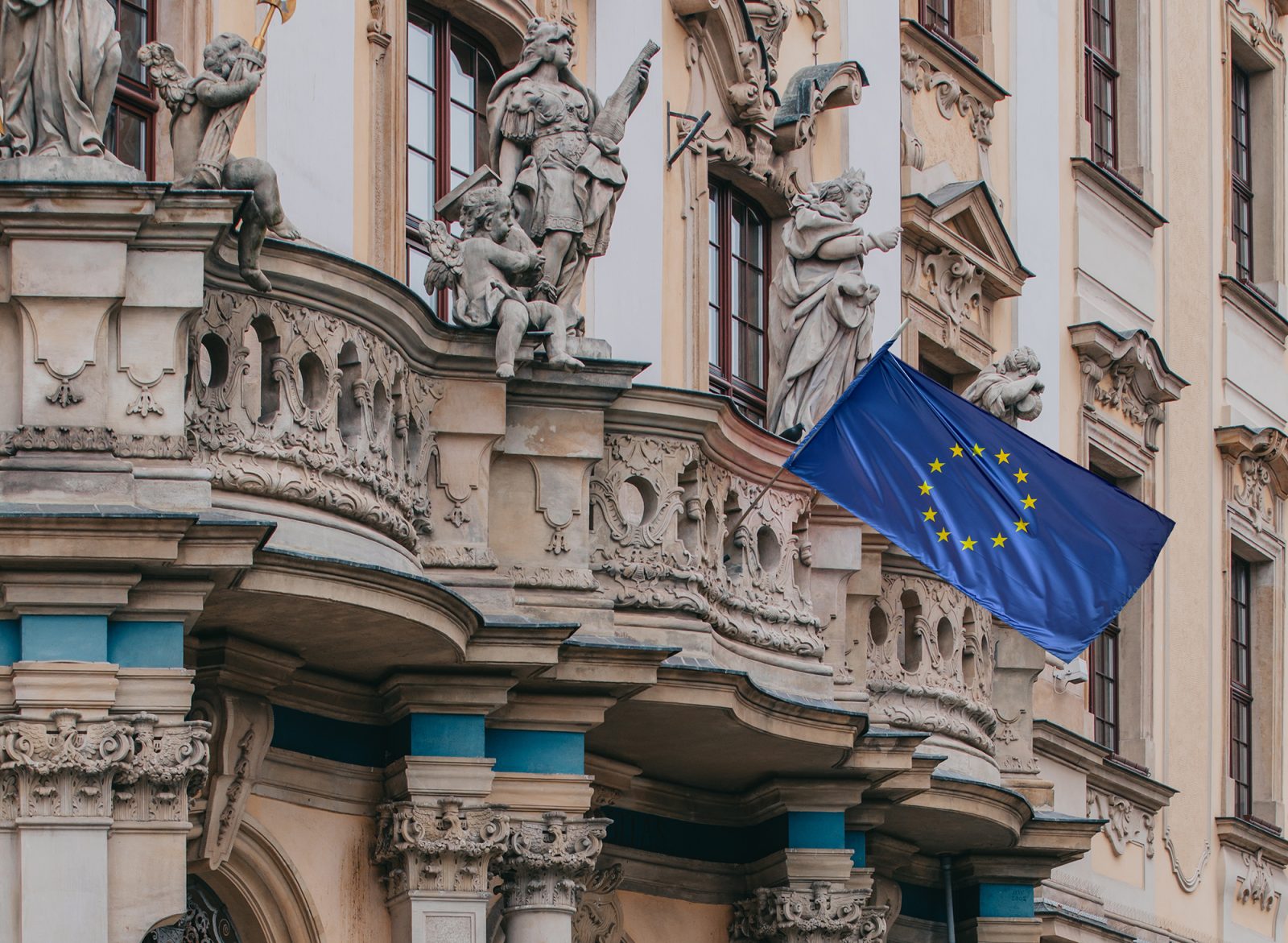 zabytkowy budynek z balkonem na którym umieszczona jest flaga
