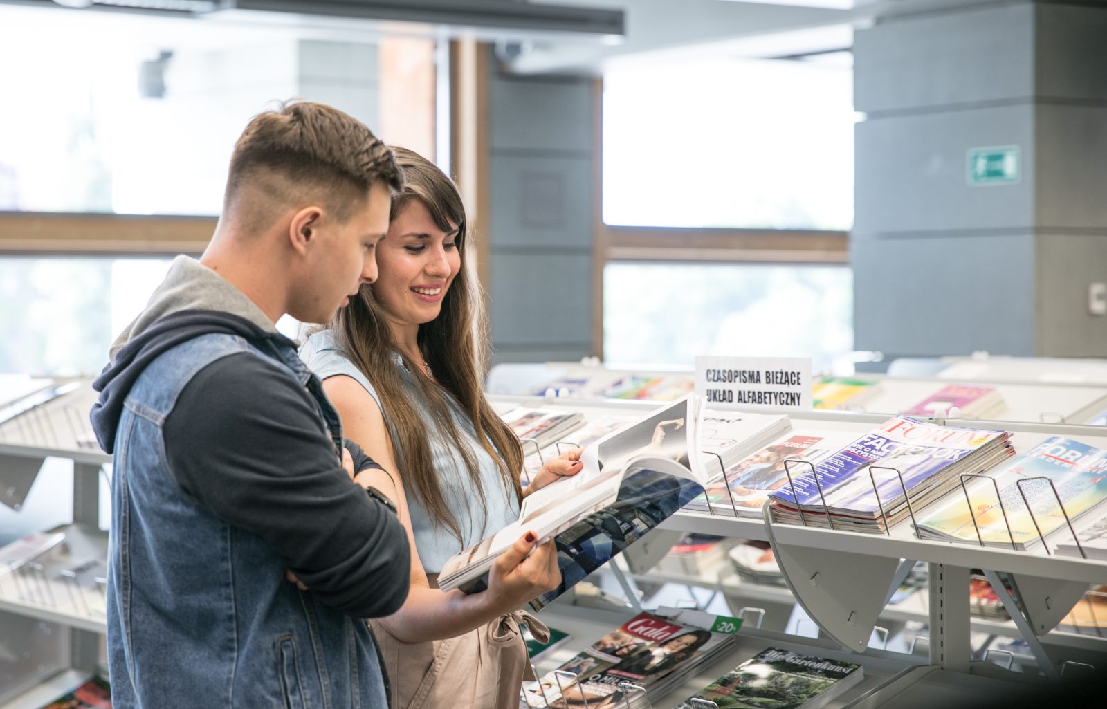 dwie osoby przeglądają czasopisma