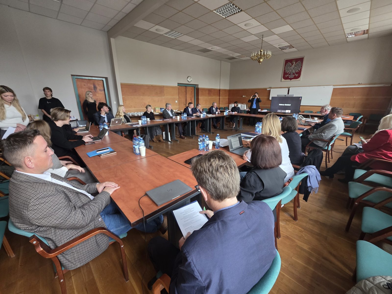 zdjęcie przedstawiające grupę osób siedzących w sali