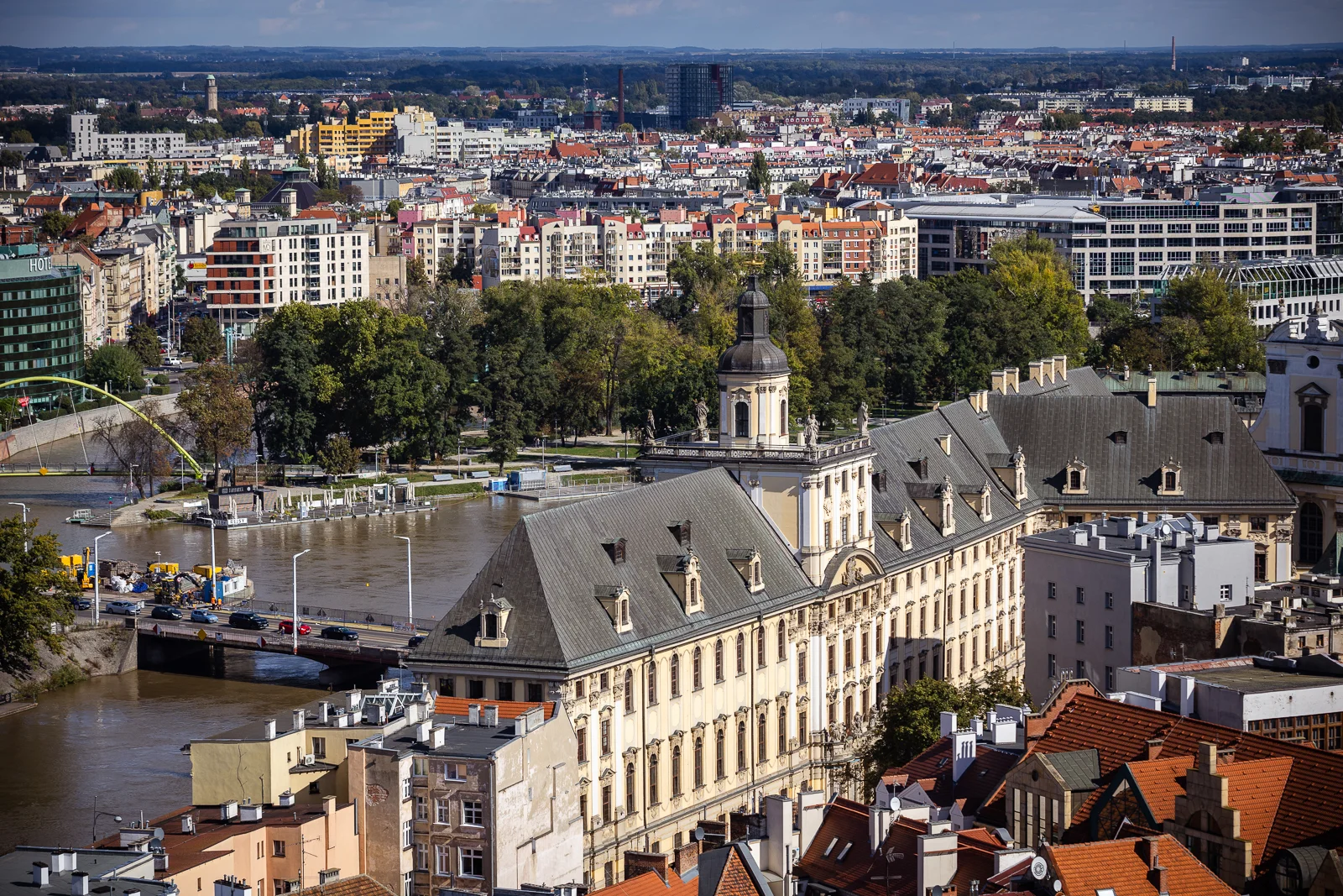 zabytkowy duży budynek w kolorze żółtym, widziany z góry, wokół inne budynki