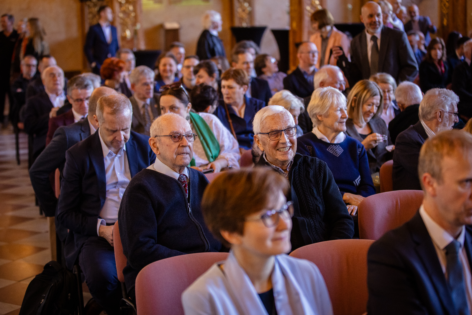 grupa ludzi w zabytkowej sali