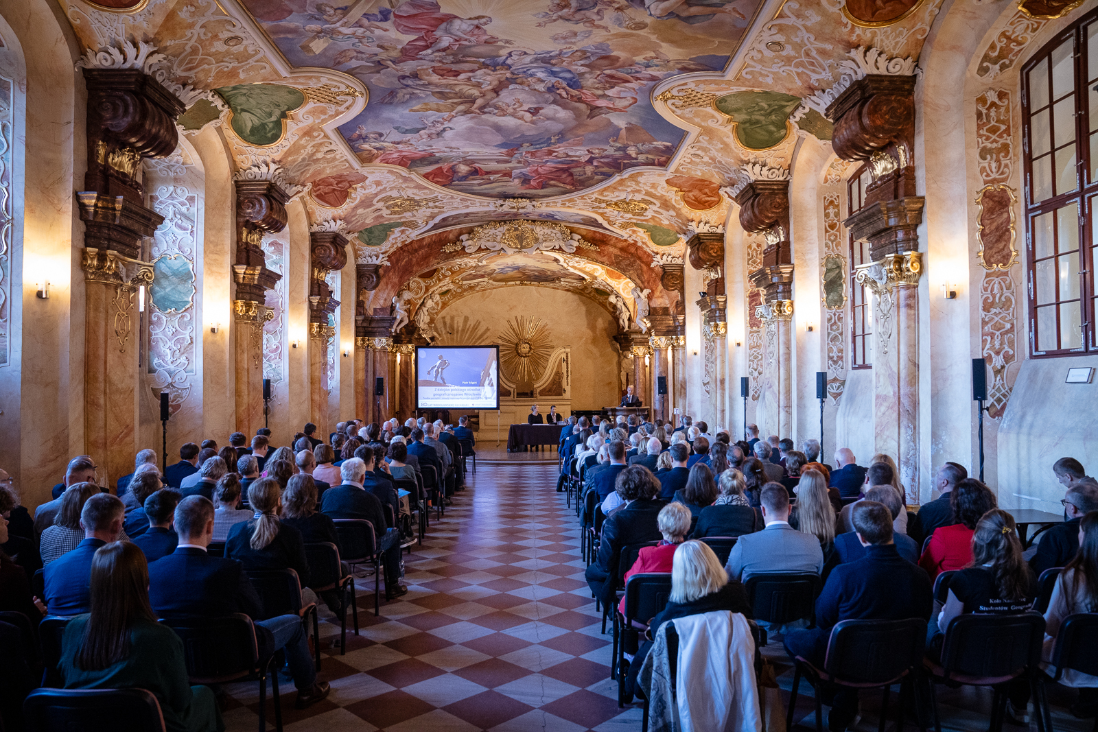 grupa ludzi w zabytkowej sali