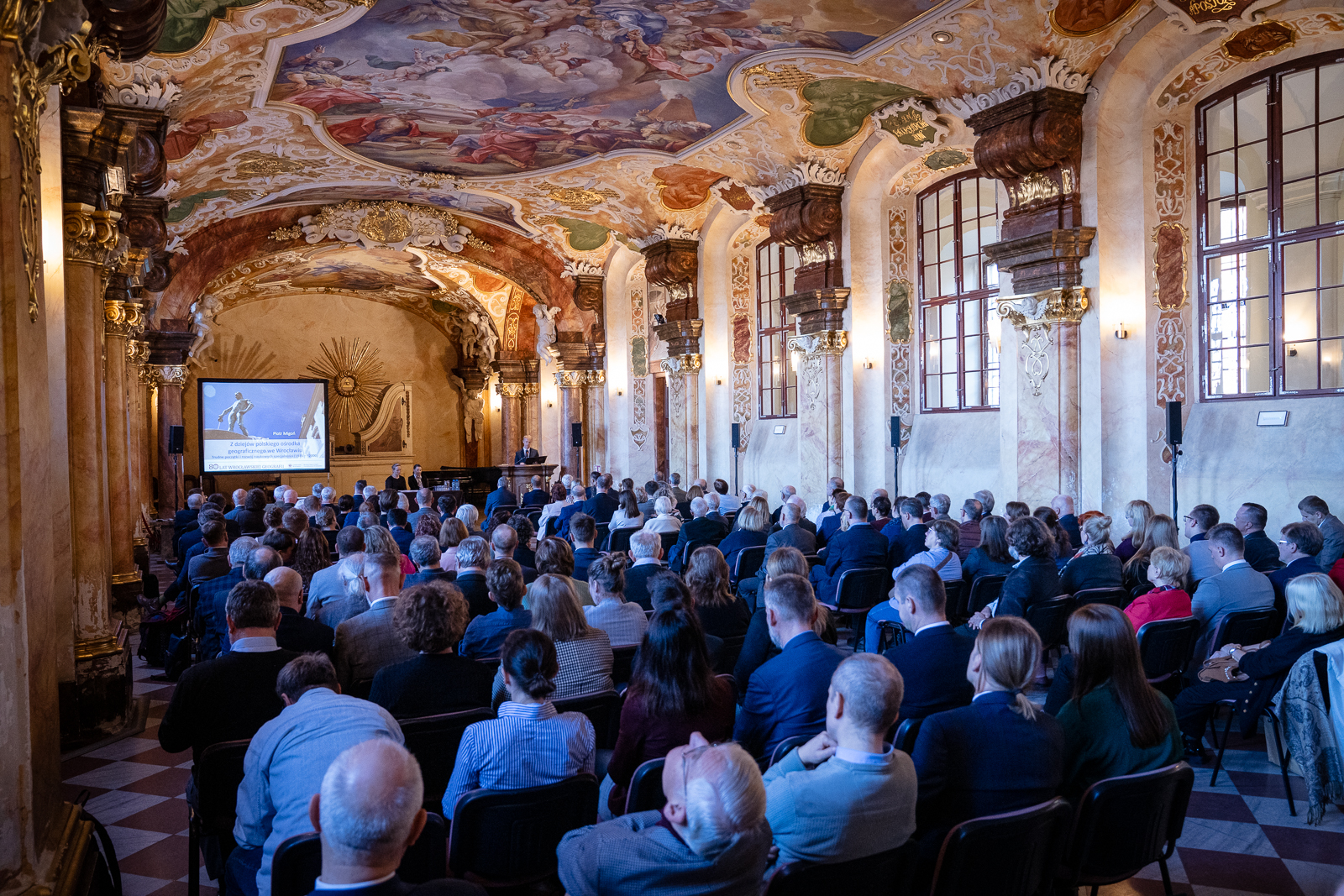 grupa ludzi w zabytkowej sali
