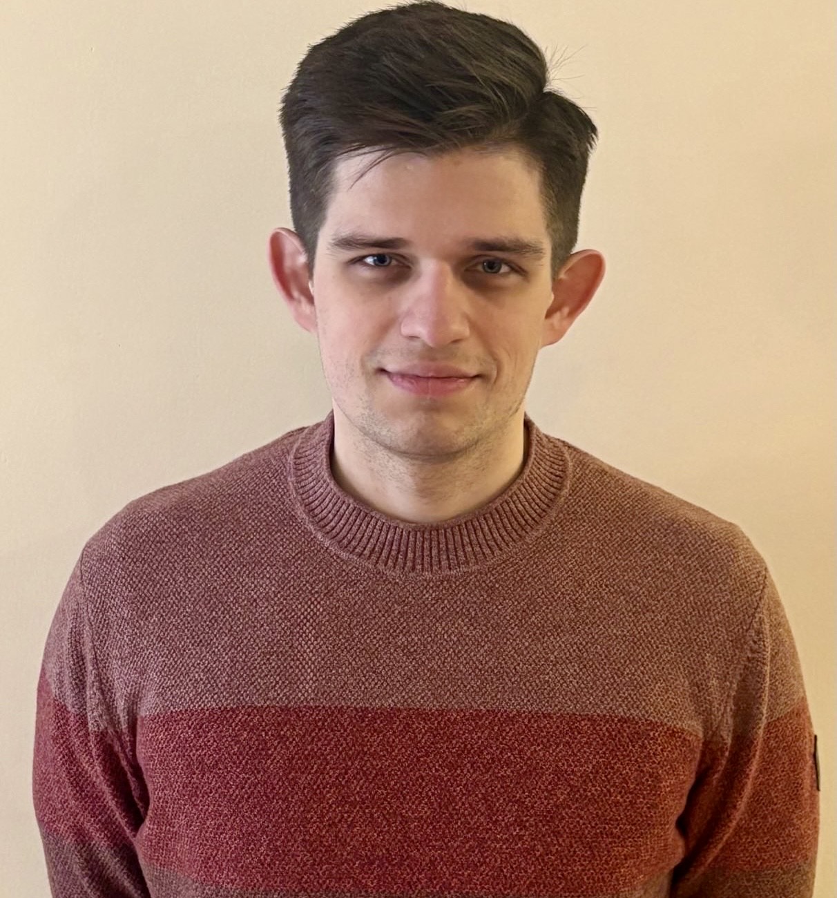 zdjęcie przedstawiające młodego, uśmiechniętego mężczyznę