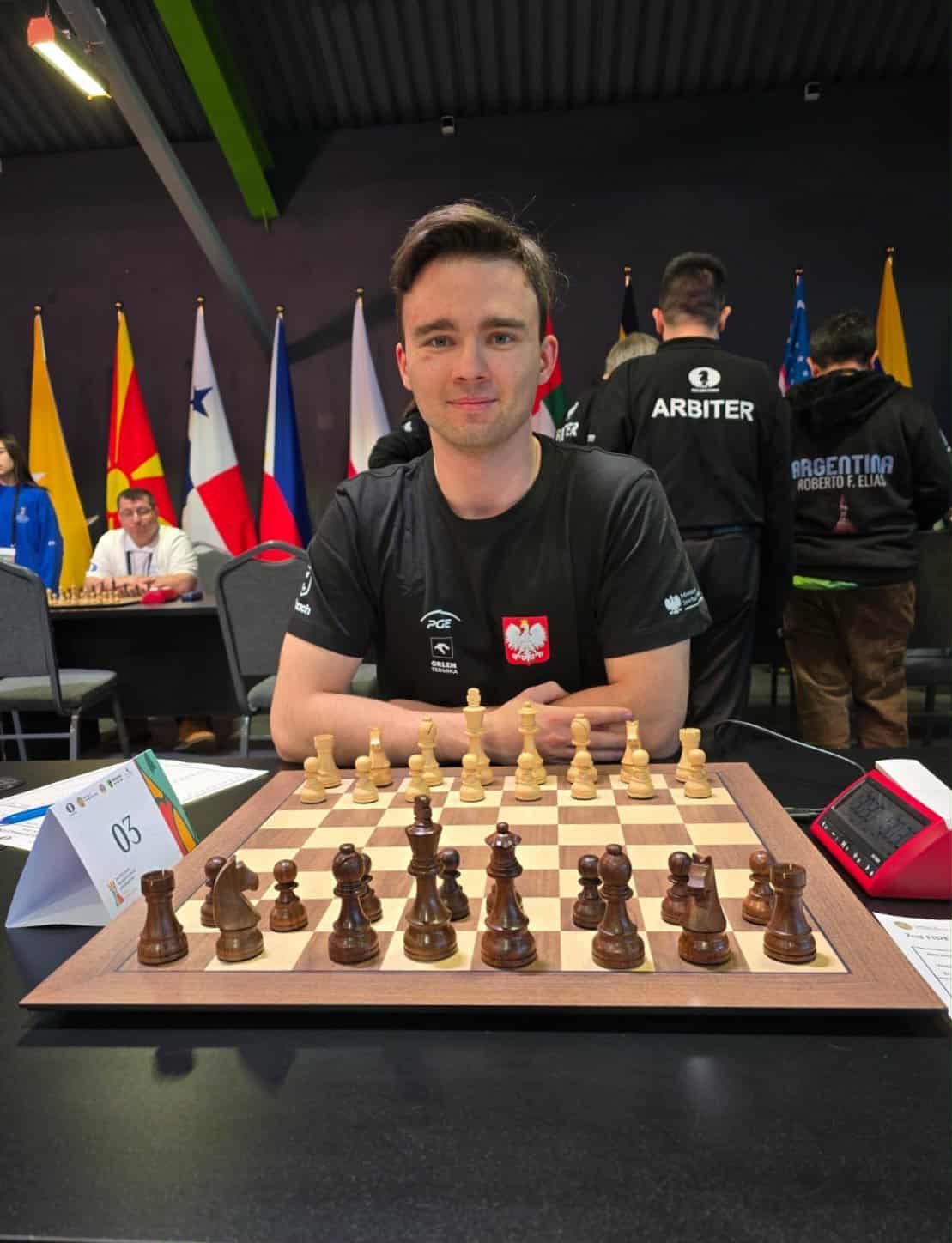 chłopak siedzący przy szachownicy na konkursie szachowym