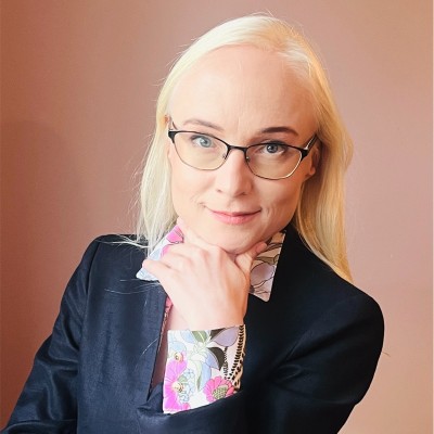 uśmiechnięta kobieta w okularach podpierająca twarz ręką