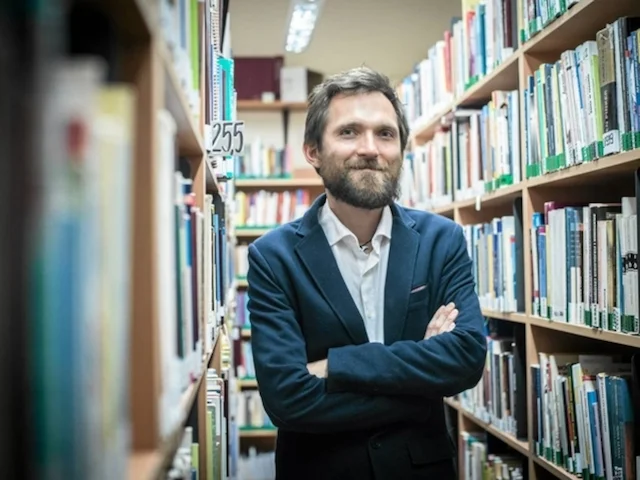 mężczyzna w marynarce w bibliotece